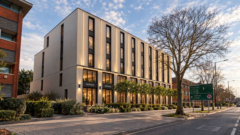 Contemporary four-storey building with warm illuminated windows at dusk