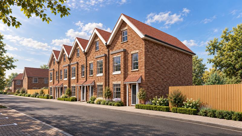 Row of new-build brick townhouses with gabled roofs